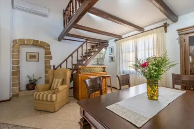 a living room with a table and a staircase at Diktamo House in Agia Marina Nea Kydonias