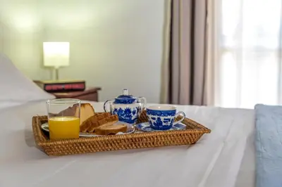 a tray of breakfast food and orange juice on a bed at Diktamo House in Agia Marina Nea Kydonias