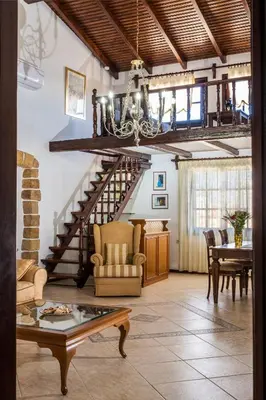 a living room with a staircase and a table at Diktamo House in Agia Marina Nea Kydonias