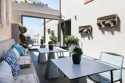 a patio with tables and chairs on a balcony at Ciel Collection Suites in Chania Town