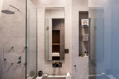 a bathroom with a shower and a sink and a mirror at Ciel Collection Suites in Chania Town