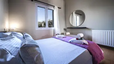 a bedroom with a bed with towels and a mirror at Petronila Luxury Villa with heated private pool in Kissamos