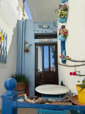 a blue door with a table in front of it at 2-Bedroom Blue & White House with Garden and Beach in Plataniás