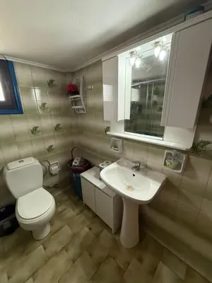 a bathroom with a white toilet and a sink at 2-Bedroom Blue & White House with Garden and Beach in Plataniás