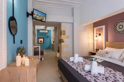 a bedroom with a large bed and a living room at Vereniki Suites Chania in Chania Town