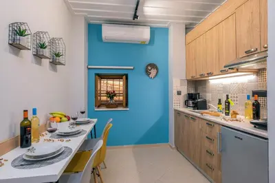a kitchen with blue walls and a table with chairs at Vereniki Suites Chania in Chania Town