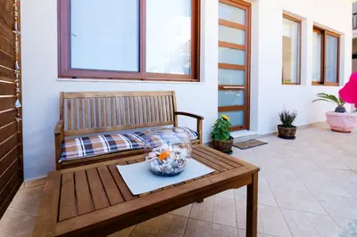 a room with a wooden bench with a vase on a table at Gina's home in Kolymvari