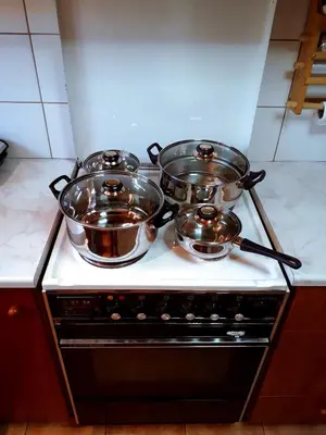 three pots and pans on a stove in a kitchen at Hidden House in Nature in Zounákion