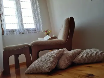 a room with a chair and a table with a window at Hidden House in Nature in Zounákion
