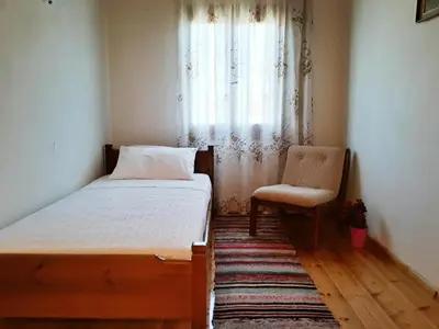 a bedroom with a bed and a chair and a window at Hidden House in Nature in Zounákion