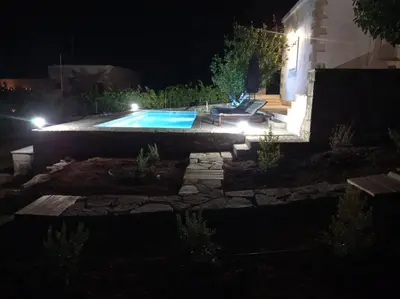 a backyard at night with a swimming pool at PALACE Mountain view in Megála Khoráfia