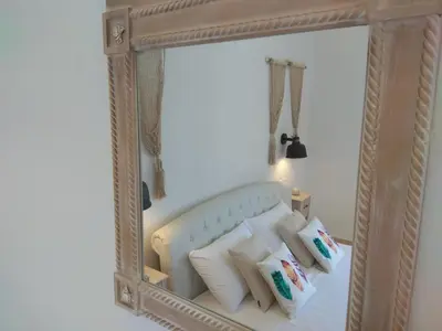 a mirror in a room with a bed with pillows at PALACE Mountain view in Megála Khoráfia