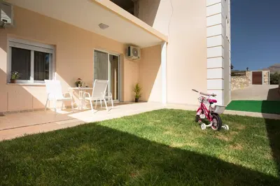 a small red bike parked in the grass in a yard at Georgia Sunset in Trákhilos