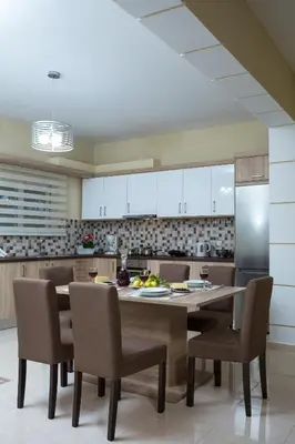 a kitchen with a table and chairs and a refrigerator at Georgia Sunset in Trákhilos