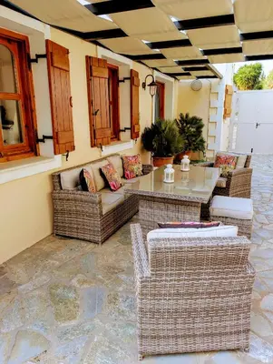 a patio with wicker chairs and a table at Villa Koumos - Crete Holidays With Pool and Views in Gavalochori