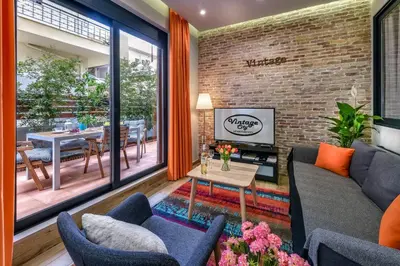 a living room with a couch and chairs and a brick wall at Vintage City Apartments in Chania Town