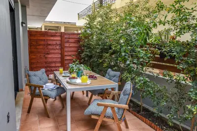 a table and chairs on a patio with plants at Vintage City Apartments in Chania Town