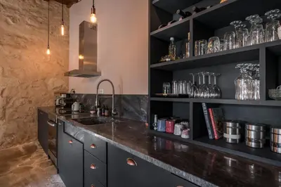 a kitchen with a sink and black shelves at Boutique Villa Kalliope in Gavalochori
