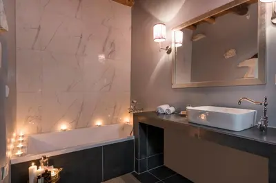 a bathroom with a tub and a sink and a mirror at Boutique Villa Kalliope in Gavalochori