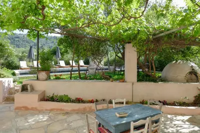 a patio with a table and chairs under a tree at Boutique Villa Kalliope in Gavalochori