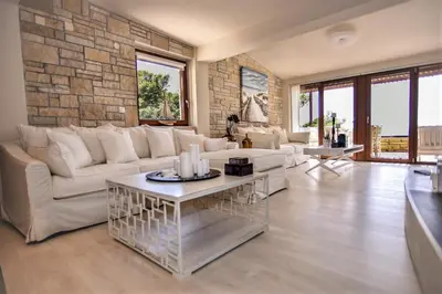 a living room with a white couch and a stone wall at Villa Evangelia in Chania Town