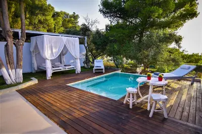 a deck with a pool and a table and chairs at Villa Evangelia in Chania Town