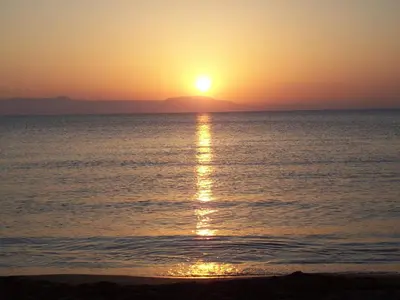 a sunset on the beach with the sun setting at Comfortable House near Chania in Kalathas