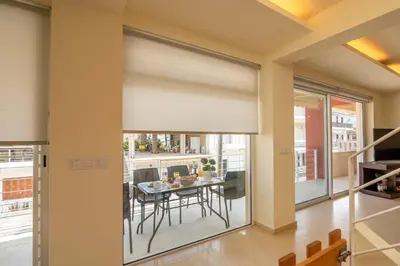 a living room with a large window with a roller blind at Luxury Maisonette in Chania Town