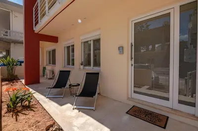 a patio with three chairs in front of a building at Luxury Maisonette in Chania Town