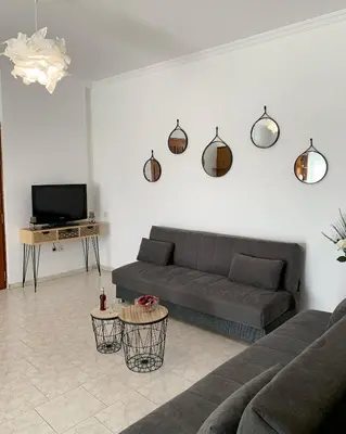 a living room with a couch and a tv at Chania Lissosaparments in Kato Daratso