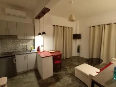 a kitchen and living room with a table and a couch at PALACE Sea view in Megála Khoráfia