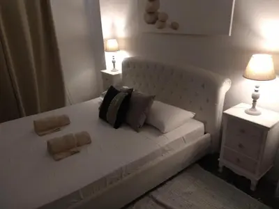 a white bed with two pillows and two lamps at PALACE Sea view in Megála Khoráfia