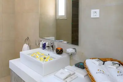 a bathroom with a white sink and a mirror at Aspasias Luxury Suite in Chania Town