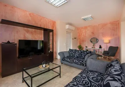 a living room with a couch and a flat screen tv at Valia's House in Kato Daratso