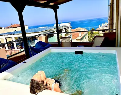 a woman laying in a hot tub on a balcony at Soleado apartment in Chania Town