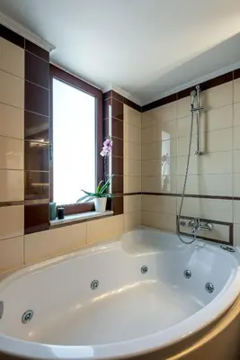 a large white tub in a bathroom with a window at Soleado apartment in Chania Town