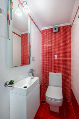 a bathroom with a white toilet and red tiles at Soleado apartment in Chania Town