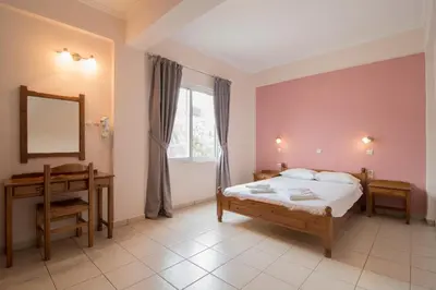 a bedroom with a bed and a desk and a window at Mediterranean Sea Down Floor in Palaiochóra