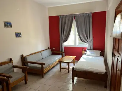 a room with two beds and a couch and a window at Mediterranean Sea Down Floor in Palaiochóra