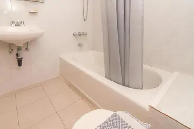 a white bathroom with a toilet and a sink at Mediterranean Sea Down Floor in Palaiochóra