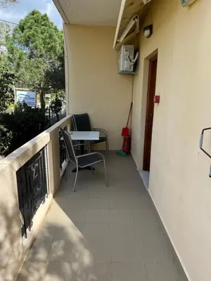 a balcony of a house with a table and a chair at Mediterranean Sea Down Floor in Palaiochóra