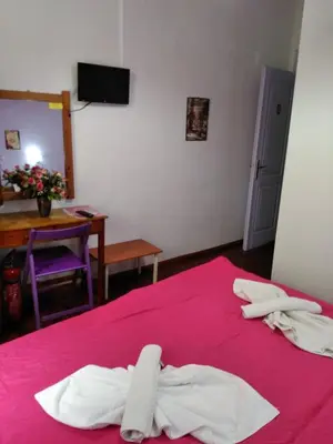 a bedroom with two white towels on a pink bed at Smaragdi in Chania Town