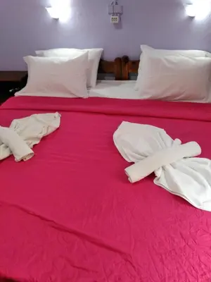 two beds with white towels on a red bedspread at Smaragdi in Chania Town