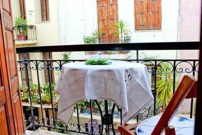 a table on a balcony with a white table cloth at Smaragdi in Chania Town