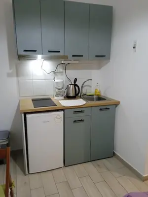 a kitchen with a sink and a stove and cabinets at Smaragdi in Chania Town