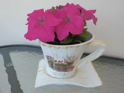 a cup with pink flowers in it sitting on a table at Charisma Apartment in Plataniás