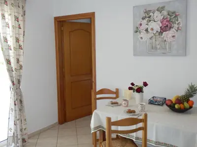 a table with a white table cloth and flowers on it at Charisma Apartment in Plataniás