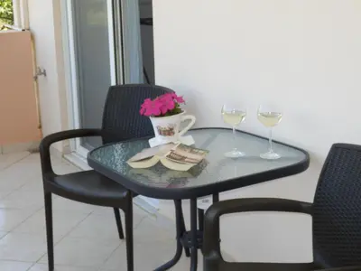 a table with two wine glasses and a vase with flowers at Charisma Apartment in Plataniás