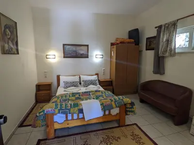 a bedroom with a bed and a couch at Modern 1-bedroom with BBQ & Roof Garden near Beach in Stalos