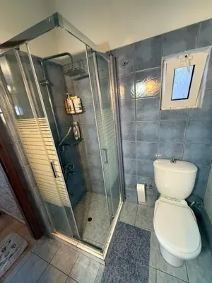 a bathroom with a shower and a toilet at Modern 1-bedroom with BBQ & Roof Garden near Beach in Stalos